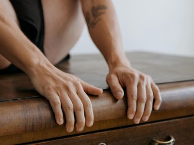 Close up of hands resting on a wooden table